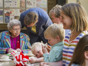 An image of a multi-generation group having fun when enjoying a cup of tea.